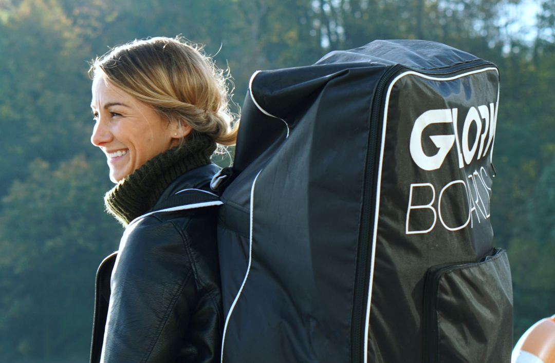 Mädchen mit Gloryboards Rucksack die im Herbst Stand Up Paddeln geht